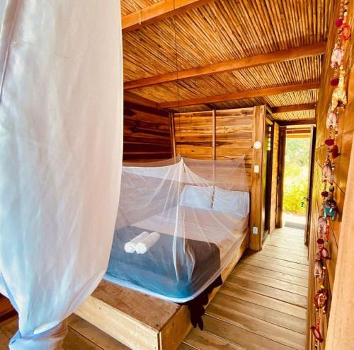 a bed in a wooden house with a net at Calma Chicha in Santa Marta