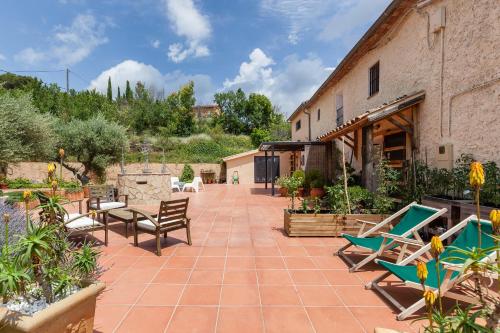 a patio with chairs and tables and a building at Masia Spa Can Pascol Casa Ecologica in Pontons