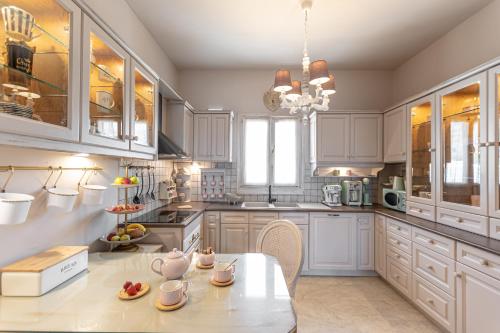 a kitchen with white cabinets and a table with fruits on it at Black Velvet in Agkidia