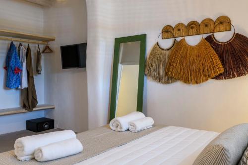 1 dormitorio con toallas en una cama con espejo en Ikos residence, en Mykonos ciudad