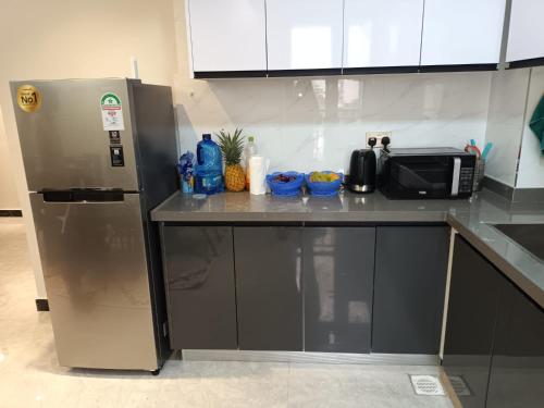 a kitchen counter with a microwave and a refrigerator at Diamond in Kileleshwa Othaya Rd in Nairobi