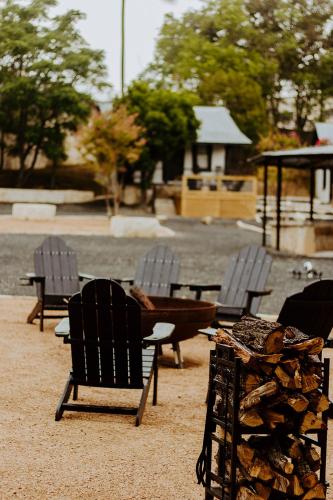 a group of chairs and a pile of fire wood at THE VAQUERO MOTEL in Bandera