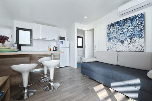 a living room with a couch and a kitchen at Mobile home Safir in Biograd na Moru