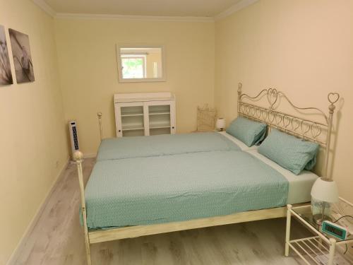 a bedroom with a bed with green sheets and a window at Das Weisse Haus Bockholt in Soltendieck