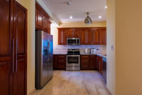 a kitchen with wooden cabinets and stainless steel appliances at Break Water Point Penthouse 7th Floor in Jacó