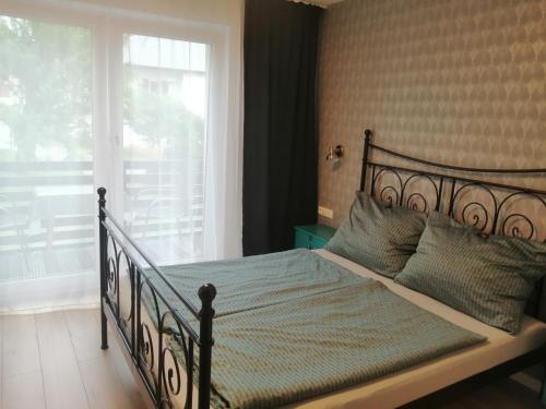um quarto com uma cama grande e uma janela em Hillside Rooms em Pörtschach am Wörthersee