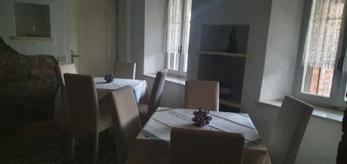 a dining room with two tables and chairs and windows at lalunanera in Cortazzone