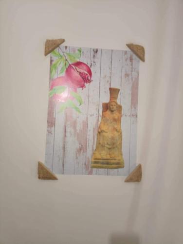 a picture of a vase with a flower on a wall at B&B Antica Hera in Foce del Sele