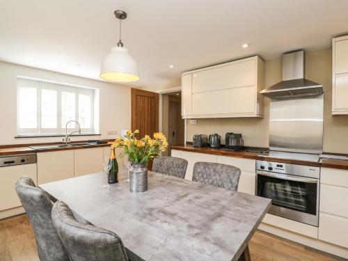 a kitchen with a table and chairs in a kitchen at The Coach House in Tetbury