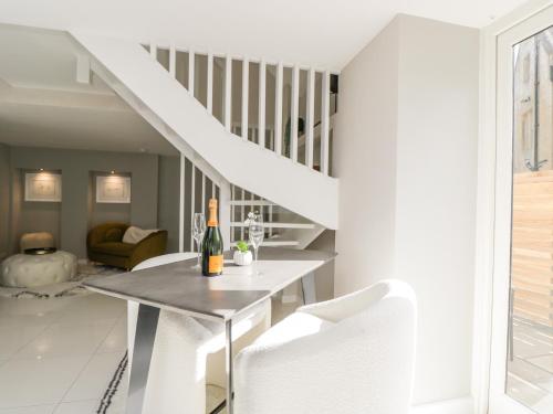 a white living room with a table and white chairs at The Hayloft in Tetbury