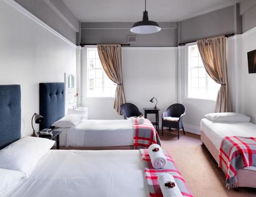 a bedroom with two beds with a teddy bear laying on the bed at Grand Hotel Sydney in Sydney