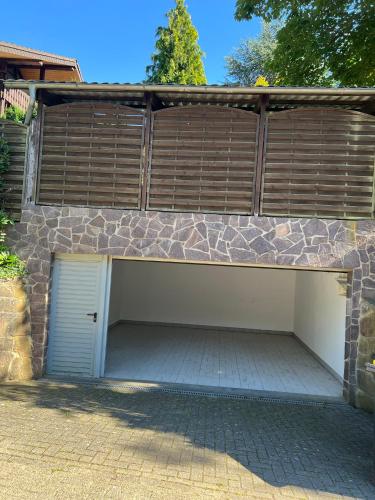 a garage with a garage door and a fence at Gästehaus zum Buchenweg in Hasenfeld