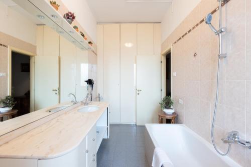 La salle de bains est pourvue de 2 lavabos, d'une baignoire et d'un miroir. dans l'établissement Montebello, Bologna by Short Holidays, à Bologne
