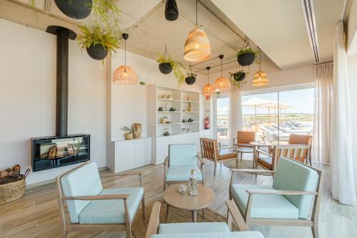 a living room with chairs and a tv and a table at Sleep & Nature Hotel in Lavre