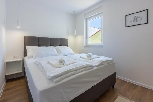 a bedroom with a bed with towels on it at Luxury Apartments Lovorka 3 & 4***/**** in Selce