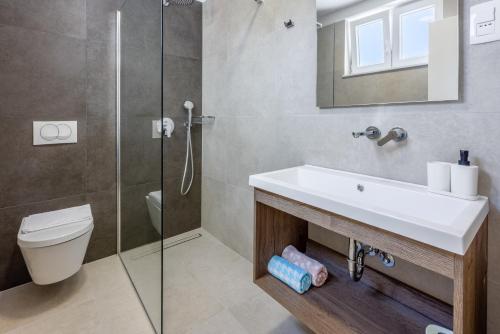 a bathroom with a sink and a toilet and a shower at Luxury Apartments Lovorka 3 & 4***/**** in Selce
