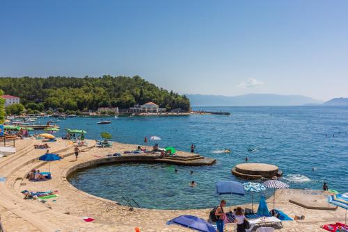 a group of people on a beach with a swimming pool at Luxury Apartments Lovorka 3 & 4***/**** in Selce