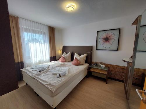 Un dormitorio con una cama grande con almohadas rosas. en Wohnambiente, en Selb