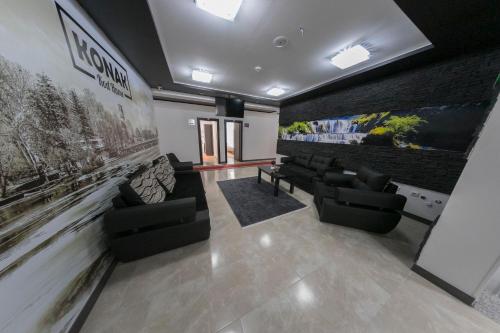 a living room with couches and a wall with posters at Konak kod Hame in Bihać