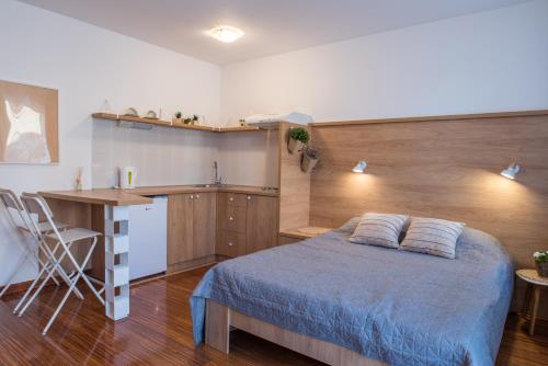1 dormitorio con cama, escritorio y cocina en Dvorištance, en Vrnjačka Banja