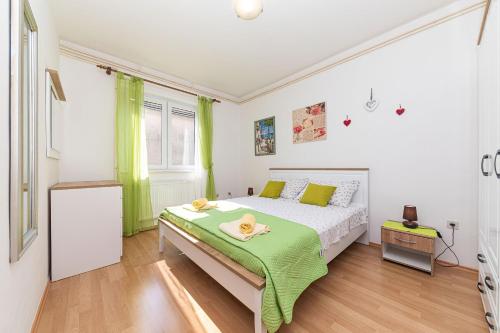 1 dormitorio con 1 cama con manta verde en Apartment 3M, en Trogir