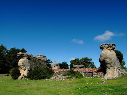 a stone building with three large rock formations at Ciudad Encantada Tio Daniel in Valdecabras
