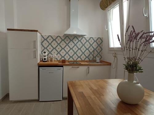 a kitchen with a table and a vase on a table at Mirador de Trafalgar Conil in Conil de la Frontera