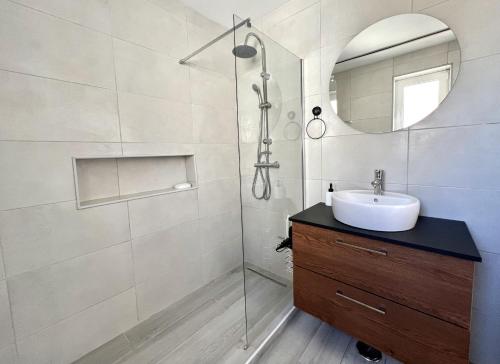 a bathroom with a sink and a shower with a mirror at Nancy Apartment - Near Vilamoura Marina by HD PROP in Vilamoura