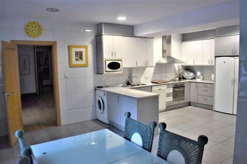 a kitchen with white appliances and a table and chairs at Casa con terrazas in Zaragoza