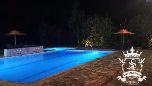a swimming pool at night with a crown on it at La Villa de San Sebastian Hotel in Villa de Leyva