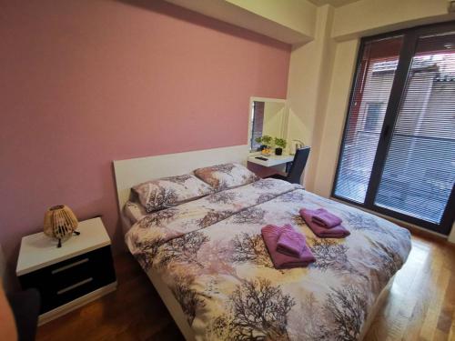 a bedroom with a bed with purple pillows on it at Exclusive Skopje Apartments in Skopje