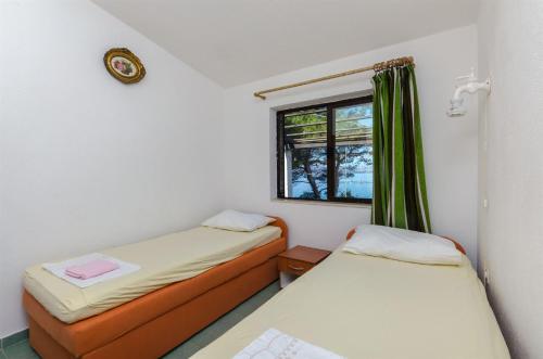a small room with two beds and a window at House Sliskovic in Rogač