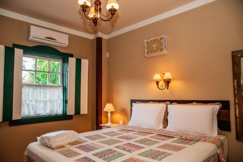 a bedroom with a large bed and a window at Tiradentes Village in Tiradentes