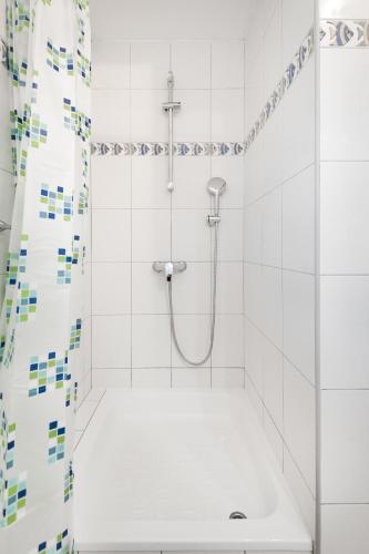 a white bathroom with a shower with a sink at Apartments Tomic in Duće