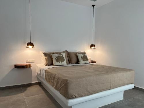 a bedroom with a large bed with two pendant lights at Villa stou Chiou in Agia Anna Naxos