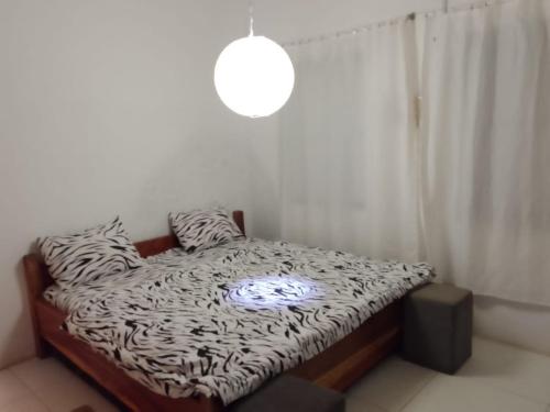 a bedroom with a zebra print bed with a light on it at Ezime Guesthouse And Pizzeria in Ada