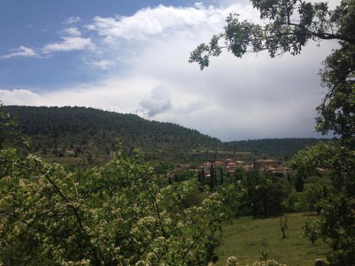 a view of a hill with a town in the distance at Ciudad Encantada Tio Daniel in Valdecabras