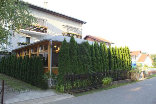 a building with a hedge in front of a house at Hotel Danica in Vrnjačka Banja