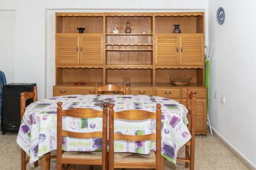 a dining room table with two chairs and a wooden cabinet at Lider, 10-B in Cullera