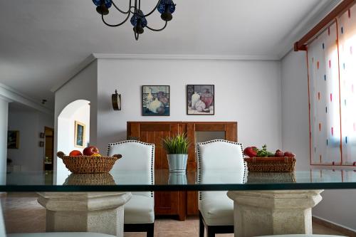 a dining room with a glass table and white chairs at Casa Anna in Costa Calma
