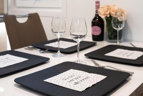 a table with two black place mats and wine glasses at The Sea Lodges Novigrad - Hausboot Floating Sea House in Novigrad Istria