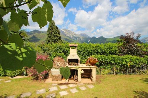 a small stove in a garden with mountains in the background at IL PICCOLO PARADISO in Seravezza