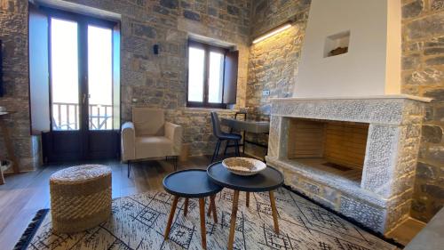 a living room with a stone fireplace and two tables at Manifest Boutique Hotel in Oítilon
