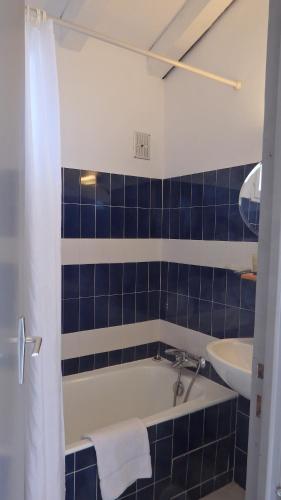 ein blau gefliestes Bad mit einer Badewanne und einem Waschbecken in der Unterkunft Résidence les Hameaux de Bocca del Oro in Porto-Vecchio