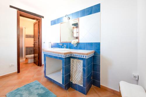uma casa de banho azul com um lavatório e um espelho em Balcone Crimaldi em San Marco dʼAlunzio