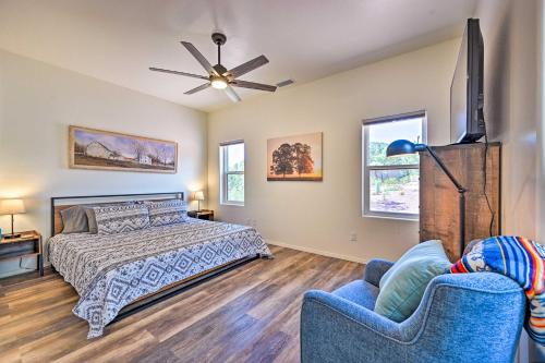 a bedroom with a bed and a tv and two chairs at Mountain High Pines Retreat with Hot Tub and Views! in Pine
