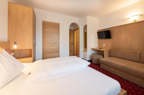 Postel nebo postele na pokoji v ubytování Hotel Gasthof Kröll - inkl Nationalpark-Karte, 1 x Grossglockner Hochalpenstraße kostenlos, verschiedene Bergbahnen kostenlos, Badesee kostenlos, Bus & Zug kostenlos, regionale Küche