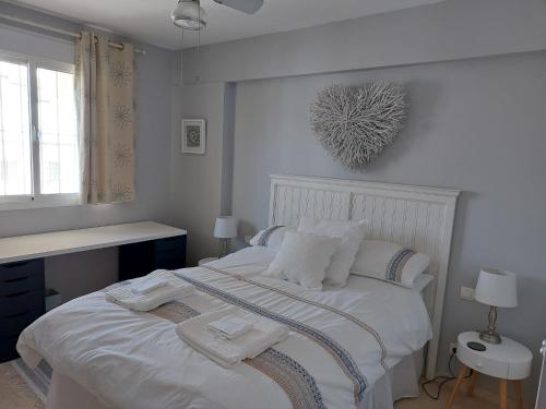 a white bedroom with a bed with white blankets and pillows at Apartment Duquesa Fairways/Manilva, Spain in Manilva