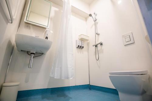 Baño blanco con lavabo y aseo en Apartment Chinatown 306, en Newcastle