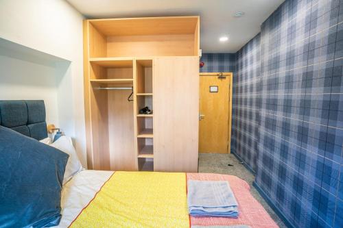 um pequeno quarto com uma cama e um armário em Apartment Chinatown 306 em Newcastle upon Tyne